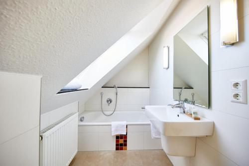 a bathroom with a sink and a bath tub at Residenz Seegras - 5 in Cuxhaven
