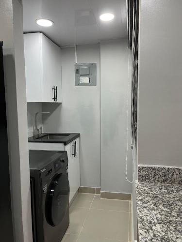 a small kitchen with a washing machine in it at Moderno Apartamento Boca Chica, 5 minutos del Aeropuerto in La Caleta