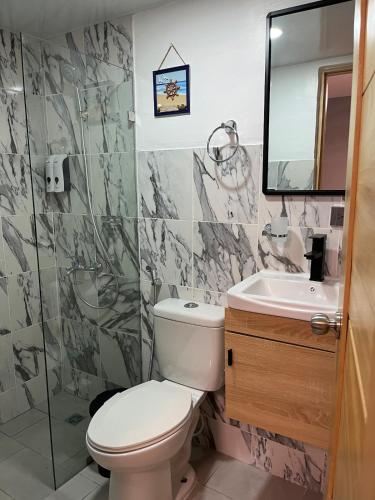 a bathroom with a toilet and a sink at Moderno Apartamento Boca Chica, 5 minutos del Aeropuerto in La Caleta
