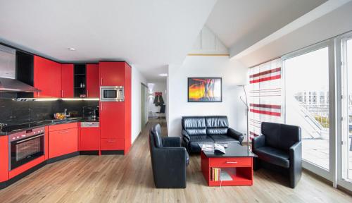 a kitchen with red cabinets and black chairs in a room at Hohe Lith - 335 in Cuxhaven