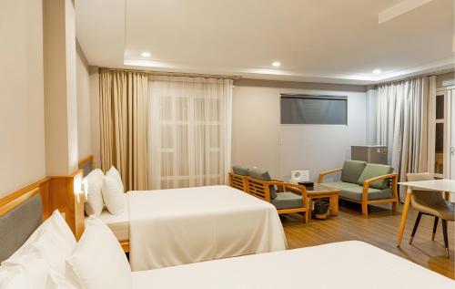 a hotel room with two beds and a tv at PH Hotel Near SECC Phu My Hung in Ho Chi Minh City