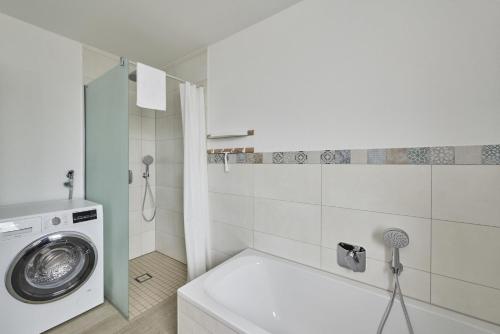a bathroom with a washing machine and a washer at City Marina - Haus 24A in Cuxhaven
