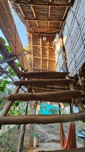 a straw hut with a hammock on top of it at Time Travellers Hostel in Auroville