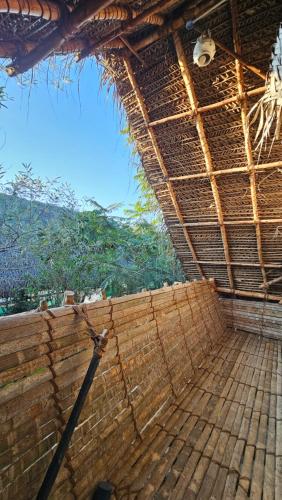 a straw roof on a building with a view at Time Travellers Hostel in Auroville