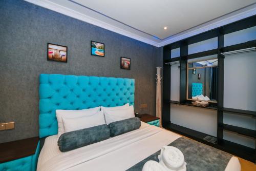 a bedroom with a blue headboard and a large bed at Baron Luxury Boutique in Nuwara Eliya