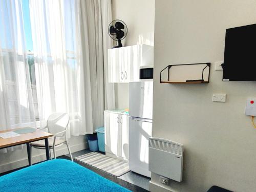 a small room with a table and a refrigerator at Work Stay at 123 in Dunedin