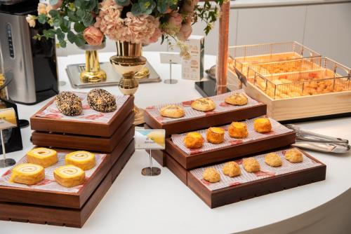a display of different types of pastries on a table at Trendy Romantic Hotel International Guangzhou Baoneng Performing Arts Center Science City Metro Station Branch - Free Deliver Service to Guangzhou Baiyun International Airport & Free Deliver Service to Canton Fair Complex During Canton Fair Period in Guangzhou