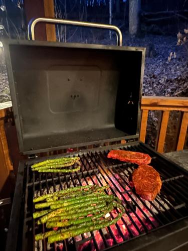 a grill with meat and vegetables on it at Little Bear Tiny Cabin in Cosby