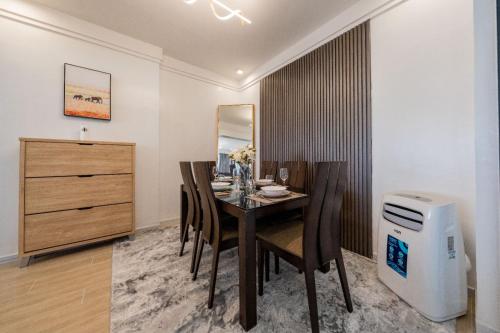 a dining room with a table and chairs and a dresser at Rieyo Homes 2 Bedrooms near Airport & SGR Train Station in Nairobi