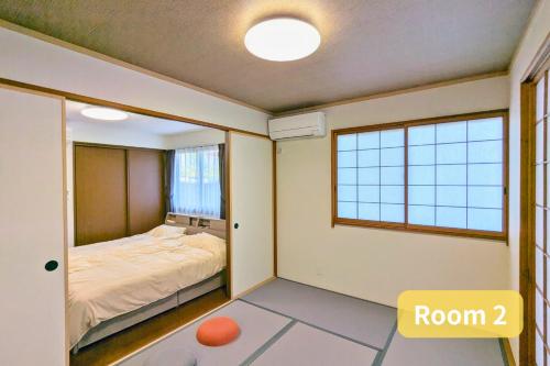 a bedroom with a bed and a window at Vacation House 1 in Funabashi