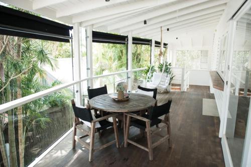 Un comedor con mesa y sillas en un balcón. en Cactus Rose Villa - Private Stay in Byron, en Brisbane