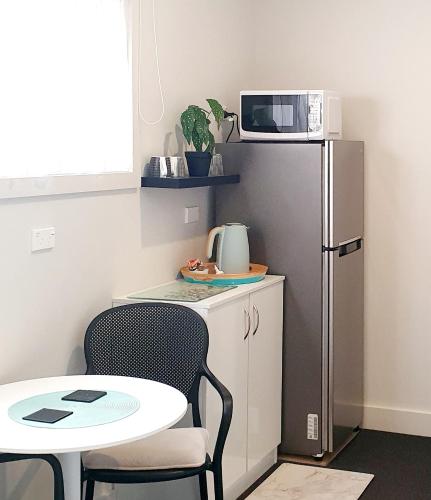 a small kitchen with a table and a refrigerator at Work Stay at 123 in Dunedin