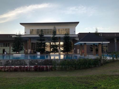 a building with a swimming pool in front of it at SMDC Cool Suite Jane's Condo in Tagaytay