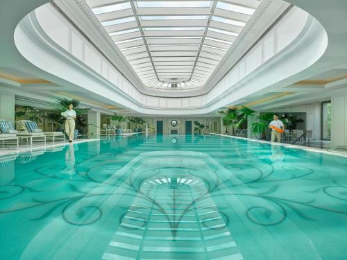 a large swimming pool in a building with a ceiling at The Peninsula Shanghai in Shanghai