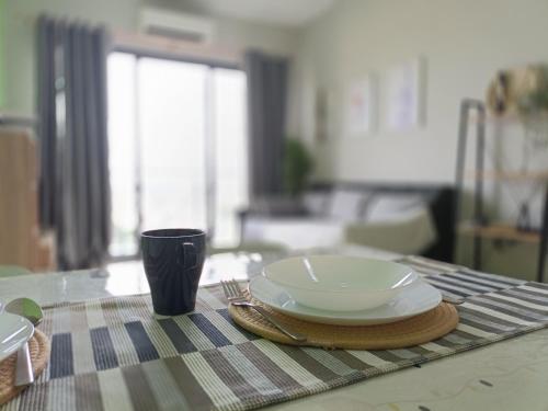 a plate and a cup sitting on a table at Prestige Sky Riverfront in Kota Bharu