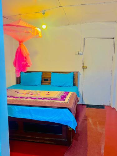 a bedroom with a bed with a colorful comforter at Dilani Adamspeak RiverStay in Adams Peak