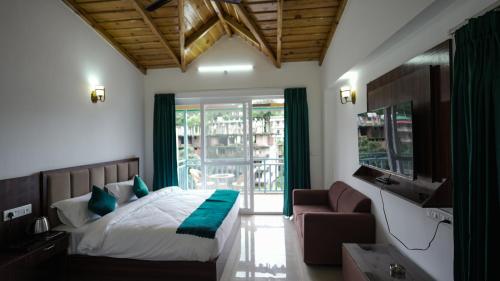 a bedroom with a bed and a couch and a window at Kalptaru The Kumaon Retreat in Bhowāli