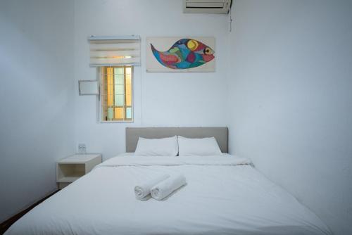 a white bed with two white towels on it at Moustachz Hauze , Georgetown in George Town