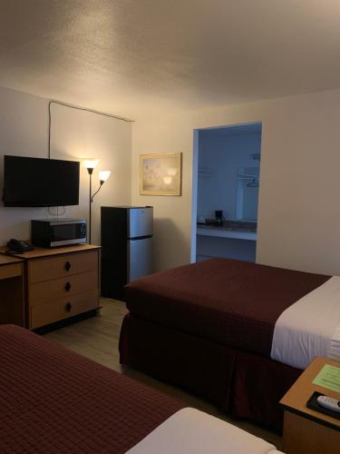 a hotel room with two beds and a flat screen tv at Motel 8 Willcox in Willcox