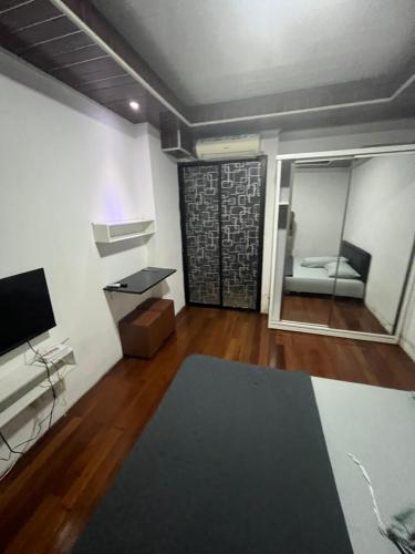 a living room with a couch and a television at Apartemen Tamansari Panoramic amanah in Bandung