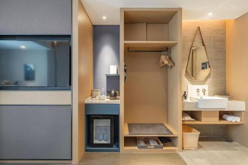 ein Badezimmer mit Waschbecken und Spiegel in der Unterkunft Atour Hotel Guangzhou Zhujiang New Town Wuyangtun in Guangzhou