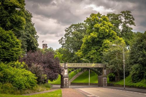 a bridge over a road in a park with trees at Hotel Courage Nijmegen in Nijmegen
