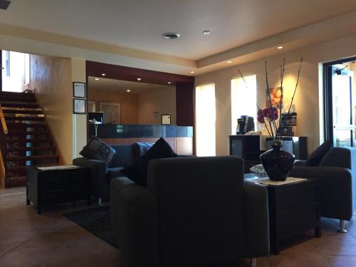 a living room with couches and a vase of flowers on a table at Hôtel Mingan in Sept-Îles