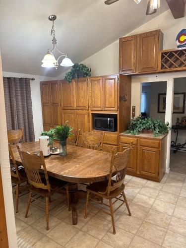 a kitchen with a wooden table and wooden cabinets at Beautiful Rocky Mountain Home with views on 1 acre in Divide