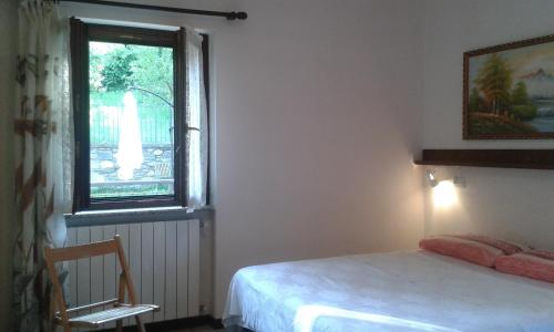 a bedroom with a bed and a window at Casa Vacanza Dal Contadino CIR O17063 in Alpe Strencia