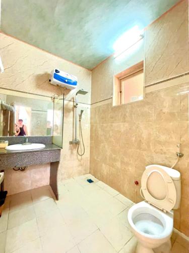 a bathroom with a toilet and a sink at Bảo Ngọc Hotel Quảng Trị in Lao Bao