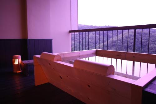 a balcony with a bench and a large window at Kakimotoya in Sango