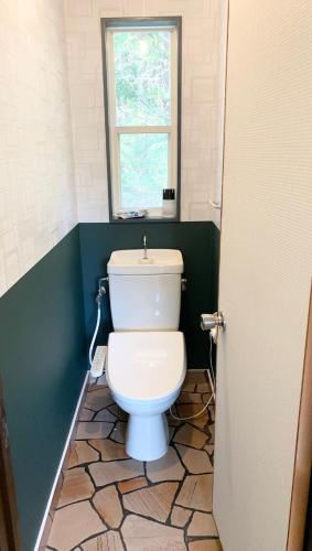 a white toilet in a bathroom with a window at ISU BASE - Vacation STAY 12851 in Shima