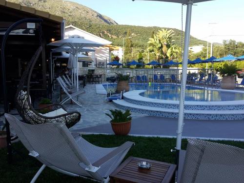 ein Resort mit einem Pool, Stühlen und Sonnenschirmen in der Unterkunft Adams Hotel in Parga