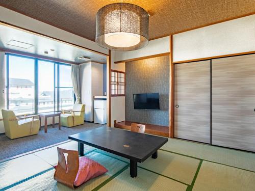 a living room with a table and a tv at Kindayu in Shibukawa