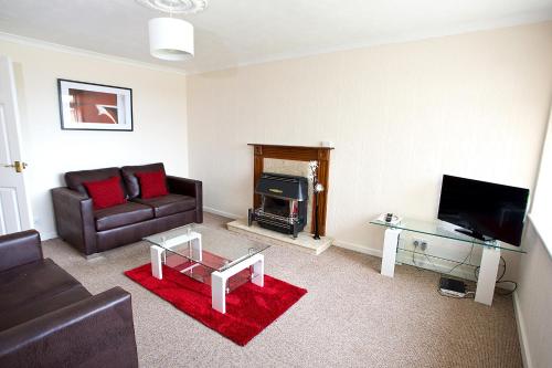 uma sala de estar com um sofá e uma lareira em Ripley Peak District Gateway em Ripley
