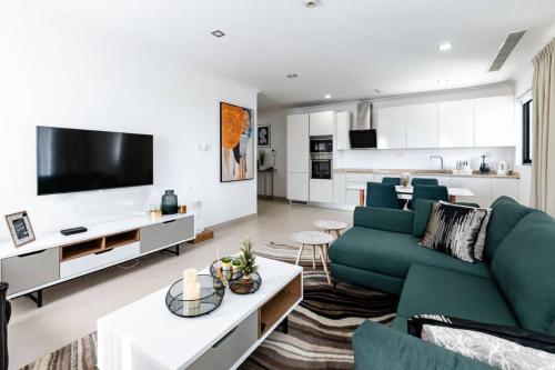 a living room with a green couch and a tv at Amazing luxurious studio Space Available in Accra