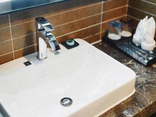 a bathroom sink with a faucet on top of it at Xana Hotelle Jinan Wuanfu Interchange Huafu International Square in Jinan