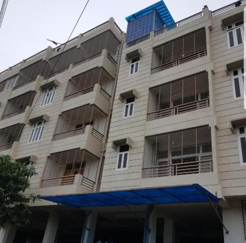 瓦拉纳西Ganga Ghat 2 BHK Apartment Near Kashi Vishwanath Temple With Parking And Lift的一座蓝色屋顶的白色大楼