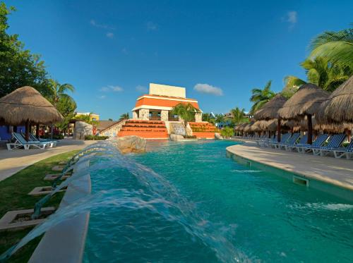 a pool at a resort with chairs and umbrellas at Iberostar Selection Paraíso Lindo - All Inclusive in Puerto Morelos