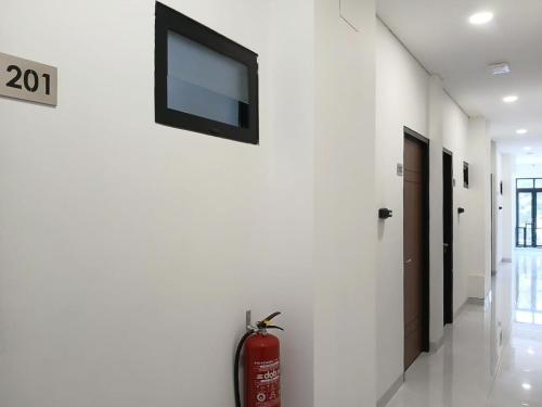 a fire extinguisher is sitting on the wall of a room at Vibes Djanti Residence Yogyakarta By Sans Hotel in Demangan
