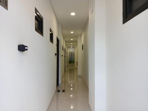 a hallway of a building with white walls at Vibes Djanti Residence Yogyakarta By Sans Hotel in Demangan