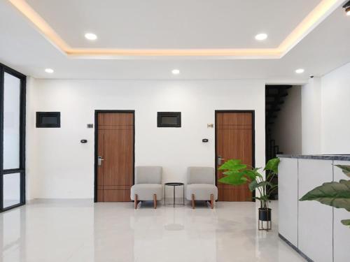 an office lobby with two chairs and a table at Vibes Djanti Residence Yogyakarta By Sans Hotel in Demangan