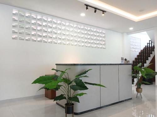 a plant in a room with a white wall at Vibes Djanti Residence Yogyakarta By Sans Hotel in Demangan