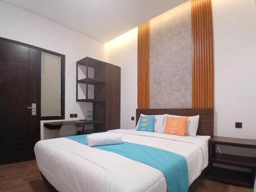 a bedroom with a large bed with colorful pillows at Vibes Djanti Residence Yogyakarta By Sans Hotel in Demangan