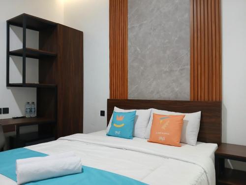 a bedroom with a bed with two pillows on it at Vibes Djanti Residence Yogyakarta By Sans Hotel in Demangan