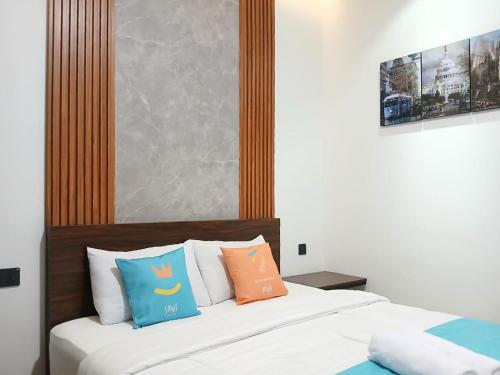 a bedroom with a bed with colorful pillows on it at Vibes Djanti Residence Yogyakarta By Sans Hotel in Demangan