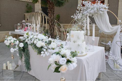 a white table with a cake and flowers on it at Museum Boutique Luxury GH in Sheki