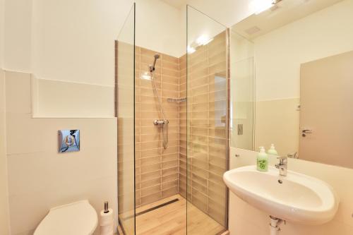 a bathroom with a shower and a toilet and a sink at Villa Oliver 2 Siófok in Siófok