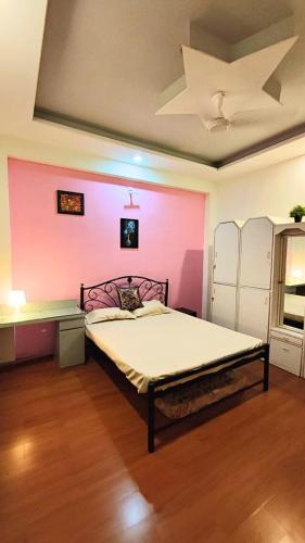 a bedroom with a bed with a pink wall at Valley View Villa Wai in Wai
