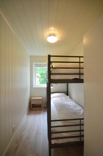 a bedroom with two bunk beds and a window at Villa Haudalan Åndalsnes in Åndalsnes